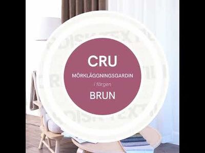 Video med panorering som visar Cru brun mörkläggningsgardin i dubbelbredd tillsammans med fåtölj, kudde, pläd, kaffekopp och tygprover på bord.