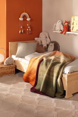 Woodland filt som ger värme och färg till säng i barnrum