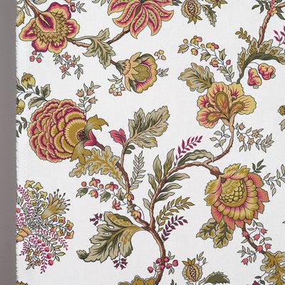 Närbild av tyg med detaljerade blommor i vinrött och gröna blad