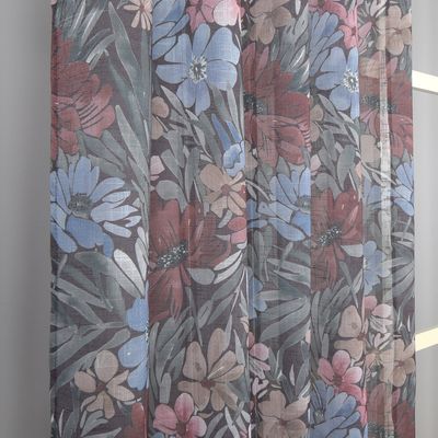 Detaljerad vy av Ruby brun gardin som hänger framför ett fönster med tydligt blommönster i varma toner