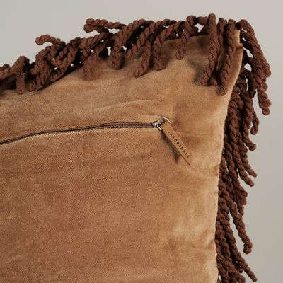 Detaljbild av Frill beige kuddfodral i sammet med dragkedja och kraftig tvinnad frans längs kanten.