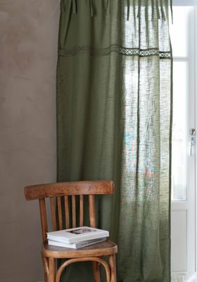 Gardinlängder Sanna grön med knytband och en dekorativ spets upphängda vid balkongdörr