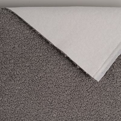 Ljusgrått möbeltyg med synlig baksida och mjuk fårpälsliknande yta