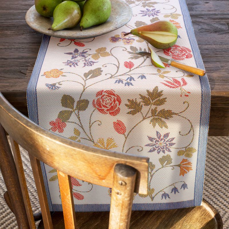Traditionell svensk bordslöpare i ekologiskt tyg prydd med romantiska blommor, GOTS-märkt för etiskt och hållbart hem.