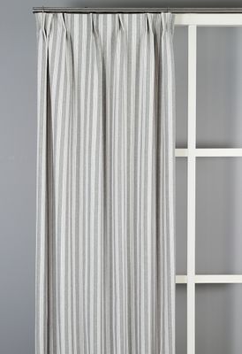 Vegani grå gardin upphängd framför fönster i ljusgrått rum, visar gardinens fall och diskreta mönster