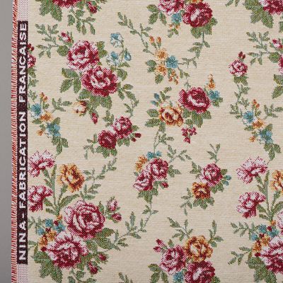 Detaljbild av Nina beige jacquardtyg med små rosor i vinrött och rosa, gröna blad och ljusblå blomdetaljer.