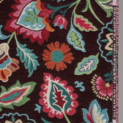 Detaljbild av Shaman svart jacquardtyg med dekorativa blommor och blad i orange, rosa, grönt och turkos mot mörk botten.