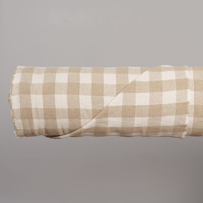 Upphängd längd av tyget Celestine beige från Safeco som visar det återkommande beige och offwhite rutmönstret över en större yta.