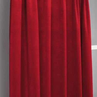 Velvet rött sammetstyg upphängt som gardin med mjuka veck, fint fall och ett levande färgspel.
