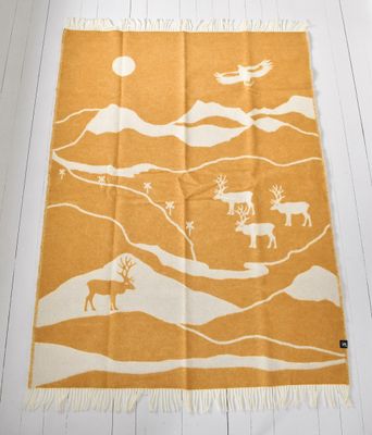 ullpläd med fjällmotiv, designad av Louise Videlyck, vackert utlagd på ett vitt trägolv.