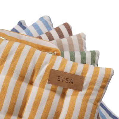 Detaljbild av Svea sittdynor i färgerna gul, äpple, sand, cognac, ljusblå och denim där den gula randiga sittdynan ligger i förgrunden. Dynorna har ett klassiskt randigt mönster och synliga knappar som ger en mjuk och ombonad känsla.
