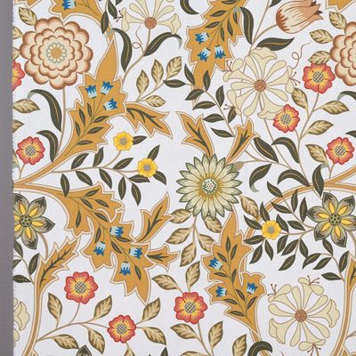 Närbild av tyg med detaljerade blommor i ockra, rött och blått