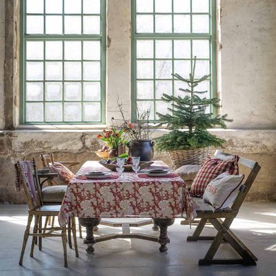 Bordduk i varma rödbruna toner med blommönster, perfekt för julbord och högtider.
