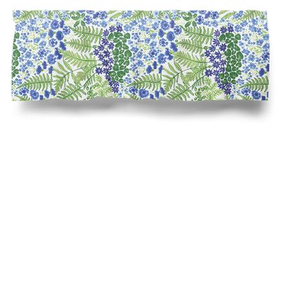 Ljus gardinkappa i metervara med blå blommor och gröna blad på vit bakgrund