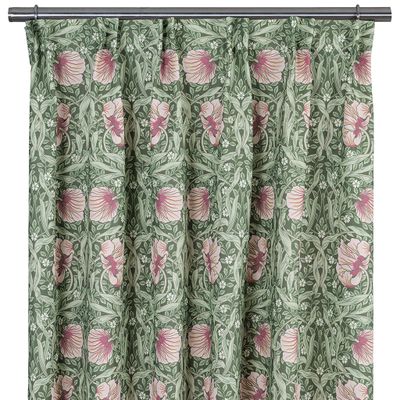 Gardin i rosa och ljusgrönt med tätt blommönster upphängd på gardinstång