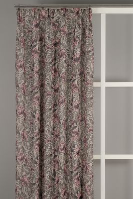 Gardiner i beige och rosa toner med bad och blommor hängande i ett fönster.