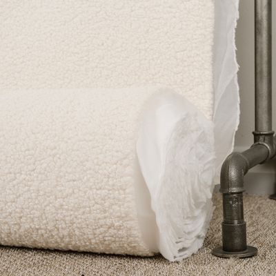 Sheep vit möbeltyg med fårpäls känsla på rulle som visar materialets struktur och tjocklek.
