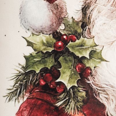 Närbild av kuddfodralet tomtefars julmotiv med gröna järneksblad, röda bär och detaljer från tomtens röda kläder och vita skägg.