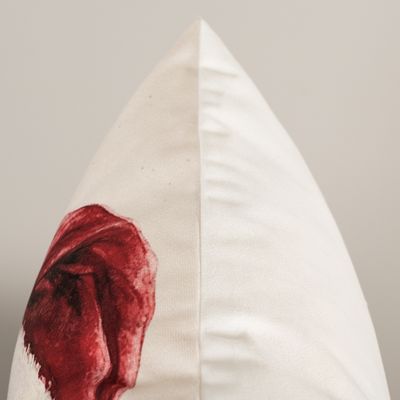 Detaljbild av kuddfodralet tomtefar som visar tygets ljusa yta, sömmen längs kanten och en del av tomtens röda luva.