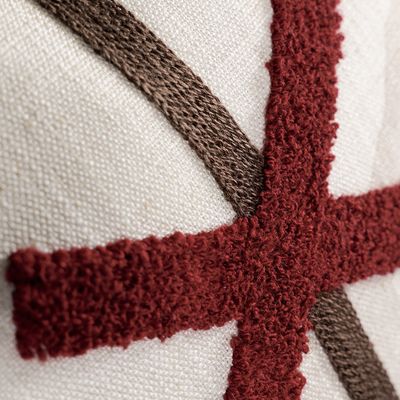 Närbild som visar de upphöjda röda broderierna och vävda detaljerna på Ledkryss kuddfodral.