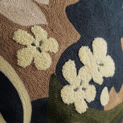 Detaljbild av Kuddfodral Monique Rost med broderade blommor och blad i beige, rostbrunt, grönt och mörkblått.