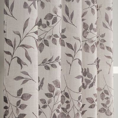 Närbild av Loke öljettgardiner med lövmönster i mullvadsgrå toner på ljusbeige slubvävt tyg.