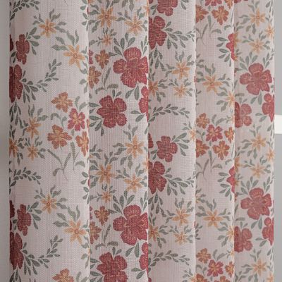 närbild av estrid rost gardin med blommor i rost och ockra samt gröna blad på ljust beige botten