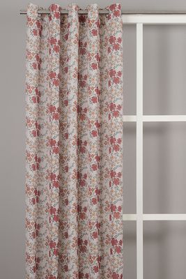 Estrid rost öljettlängder med blommigt mönster i rost och ockra framför fönster