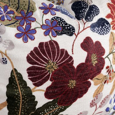 Närbild på Laura kuddfodral som visar broderade blommor i vinröda nyanser och vävd struktur.