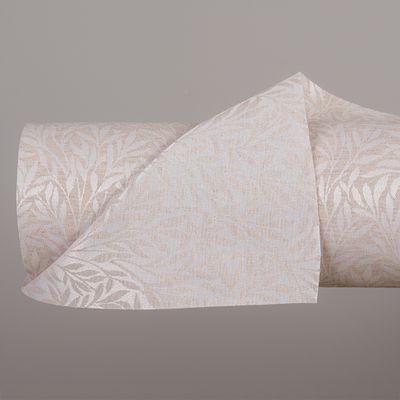 Madeleine beige textilvaxduk med skira blad i beige ton. Jaquardvävd så mönstret blit inverterat till baksidan av duken.