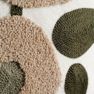 Detaljbild av Sabina kuddfodral som visar kombinationen av mjuk teddybotten och broderade blad och blommor i naturtoner.