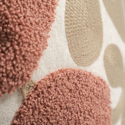 Detaljbild som visar kontrasten mellan mjuk teddy och broderade blomformer på Sabina rosa kuddfodral.