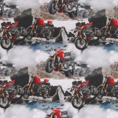 Digitaltryckt trikåtyg med grå botten och motorcyklar på gots certifierad ekologisk bomull.