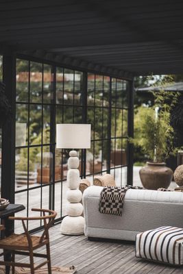 Delia pläd med rutmönster draperad över ljus soffa i modern miljö med stora fönster