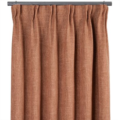 Rostfärgad 100% mörkläggningsgardin med fyllig vävd struktur upphängd på gardinstång.