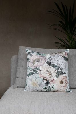 Pion offwhite kuddfodral i mjuk sammet med ett uttrycksfullt blomstermönster av pioner i en soffa