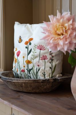 Offwhite kuddfodral Sofia med broderat blommönster placerat i dekorativ hemmiljö