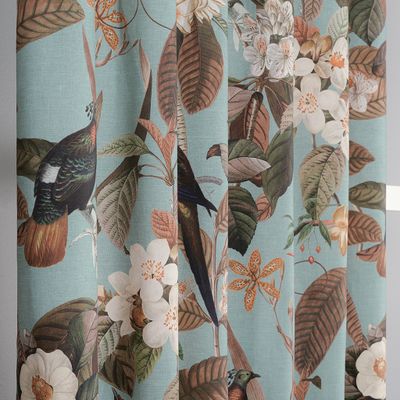 Närbild av Philodendron gardiner som visar exotiska fåglar, stora blad och blommande grenar mot turkos botten.