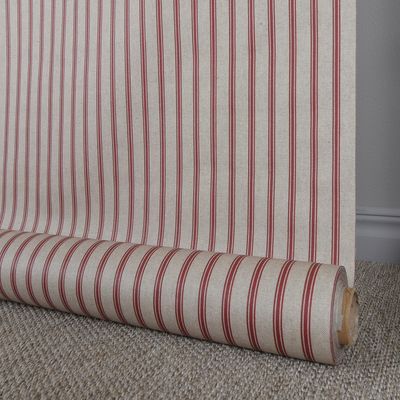 Natan textilvaxduk upprullad mot vägg, visar randigt mönster och textilstruktur