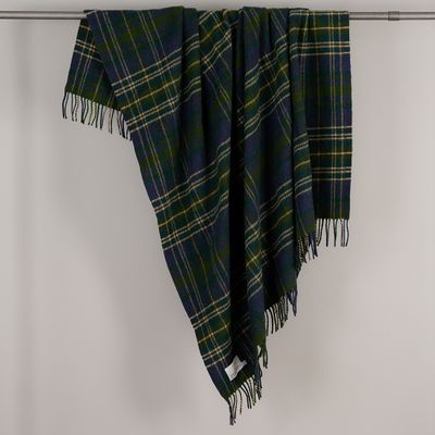 Ullpläd Forest från Tweedmill draperad över en stång, med grönt och marinblått rutmönster och fransar