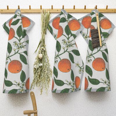 Hållbar design handduk i ekologiskt material med apelsiner och blommor, tillverkad i Sverige.