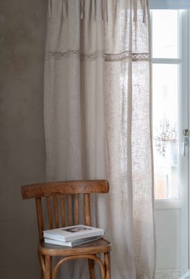 Sanna beige knytbandsgardiner med dekorativt spetsband upphöngda vid en balkongdörr